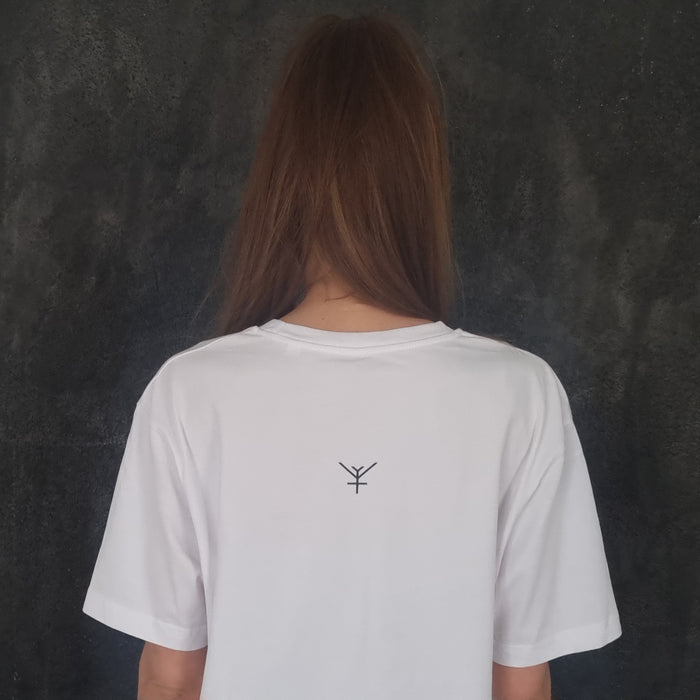 A model wearing a white oversized t-shirt with a Yulunga brand black logo printed on the back