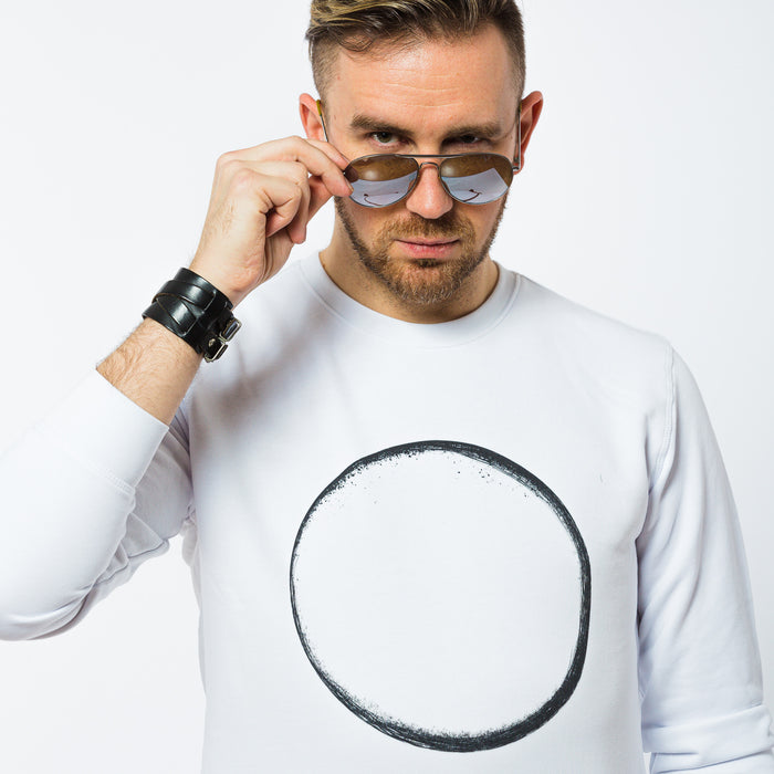 A man in a white sweatshirt made of organic cotton with a black thin circle print in the front