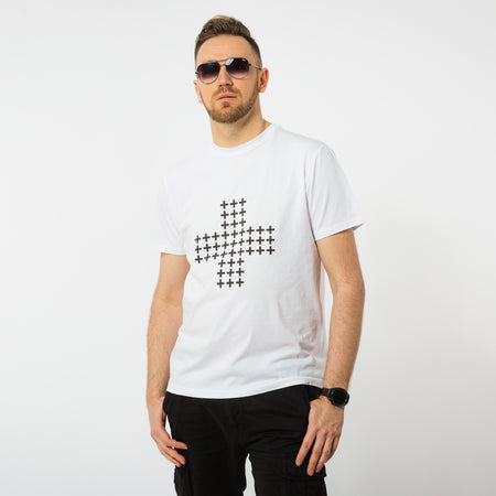 A male wearing a white eco-friendly t-shirt with a print of a black cross shape made of smaller black crosses