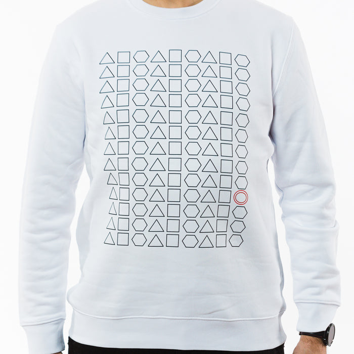 A person wearing a white sweatshirt made of sustainable materials with a black geometric graphic print made of squares, triangles and hexagons but with one red circle between them.