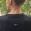 rear shot of female model in a black tshirt with subtle white logo print