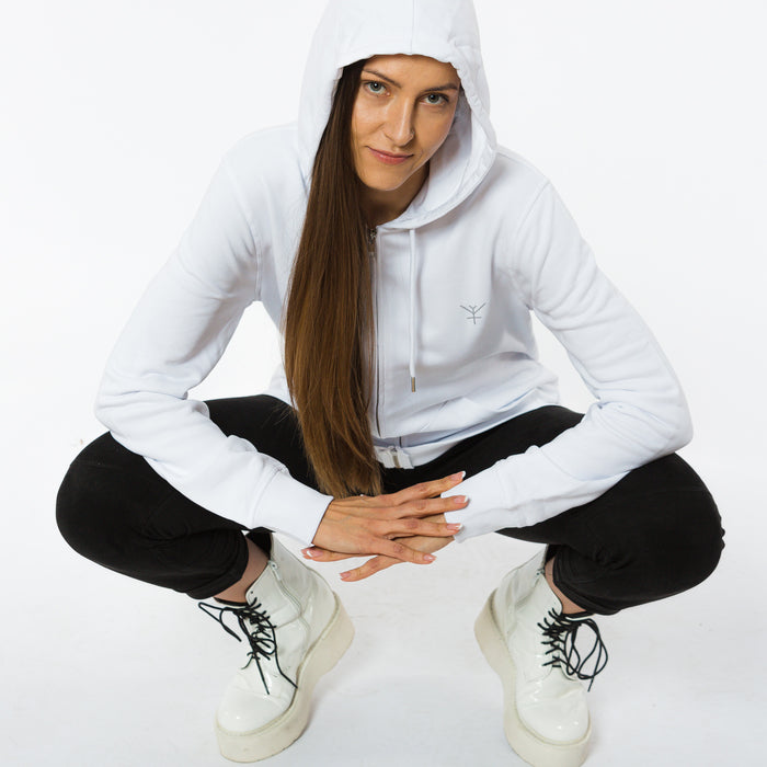 A female wearing a white unisex lightweight hoodie with a small grey Yulunga brand logo printed on the left breast