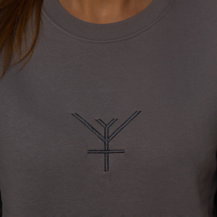 A close up on an ethical sweatshirt in lavender grey with a grey Yulunga brand logo embroidery