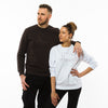 A male and a female wearing sweatshirts in brown and white with a minimalistic and delicate mammoth image printed in light brown colour in the front. The sweatshirts are by Yulunga brand and made of organic cotton.