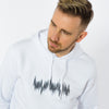 A male wearing a unisex white hoodie in minimalistic style with a black sound waves print.